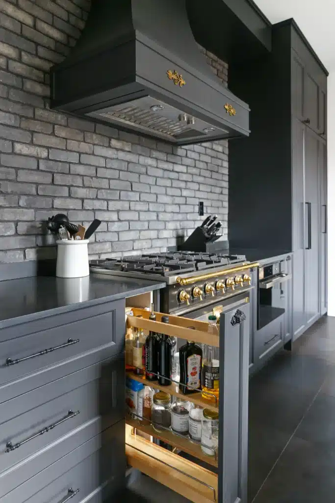 Custom Victorian kitchen renovation in Toronto with gas range, brick backsplash, and built-in pull-out pantry storage