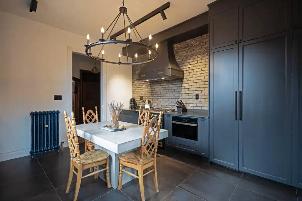 Victorian kitchen renovation in Toronto with dark custom cabinetry, farmhouse sink, and brass fixtures