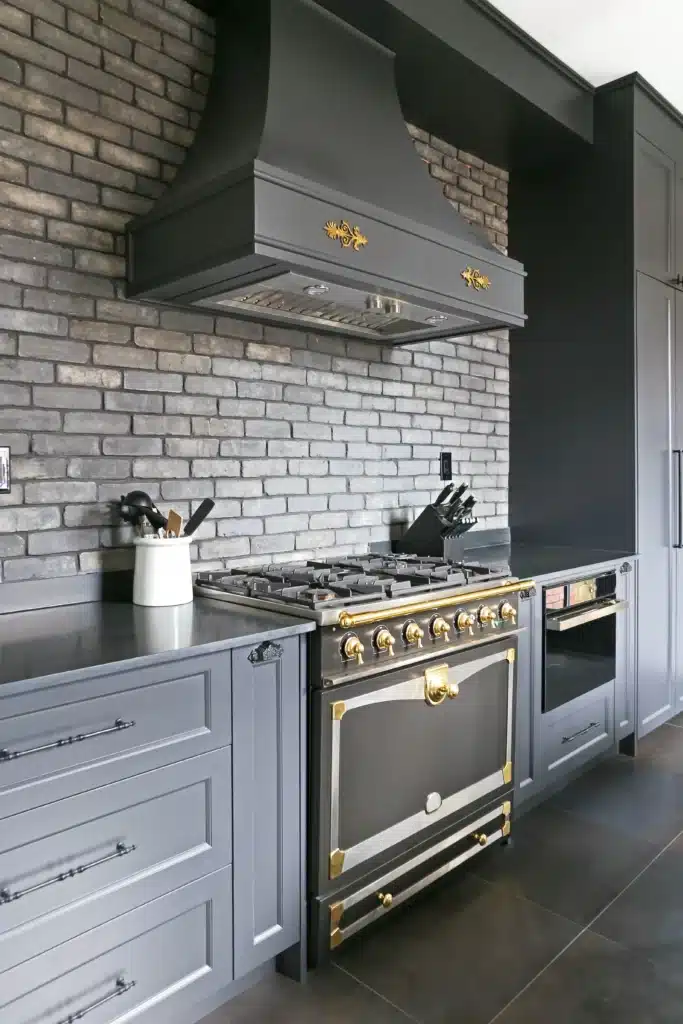 Victorian kitchen renovation in Toronto with dark custom cabinetry, farmhouse sink, and brass fixtures