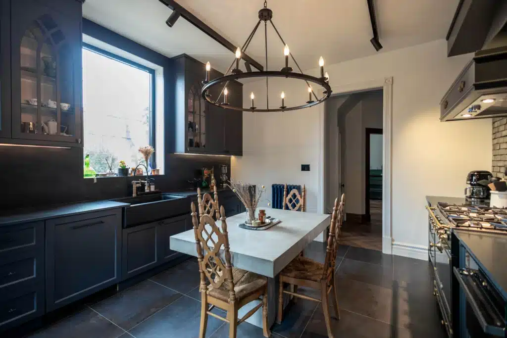 Victorian kitchen renovation in Toronto with dark custom cabinetry, farmhouse sink, and brass fixtures