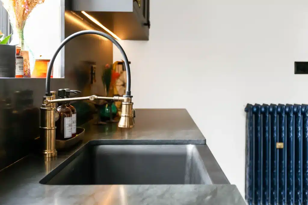 Victorian kitchen renovation in Toronto with dark custom cabinetry, farmhouse sink, and brass fixtures