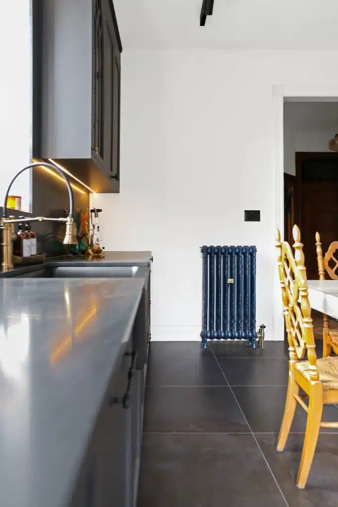 Victorian kitchen renovation in Toronto with dark custom cabinetry, farmhouse sink, and brass fixtures