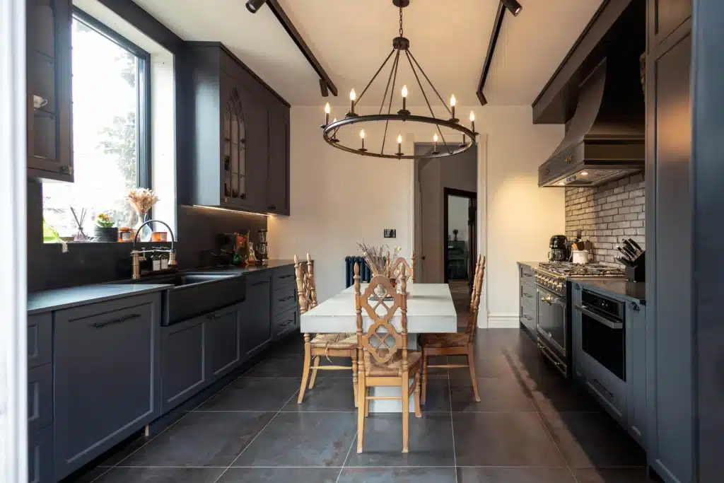 Victorian kitchen renovation in Toronto with dark custom cabinetry, farmhouse sink, and brass fixtures