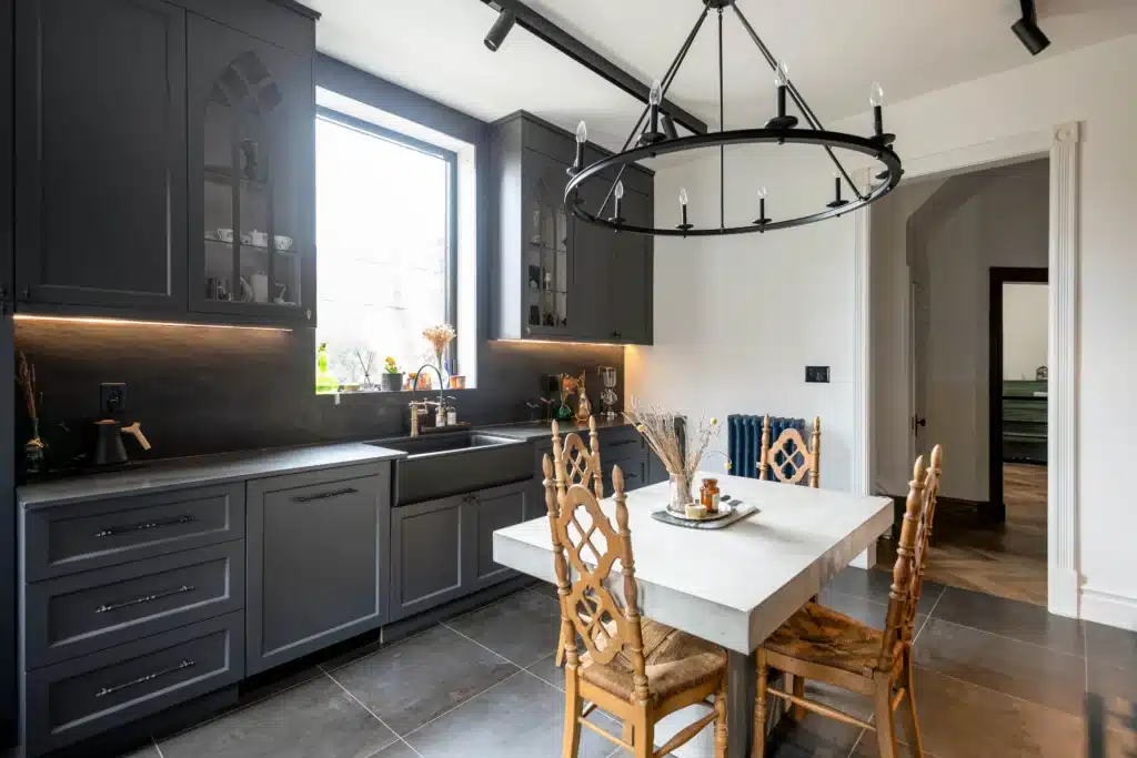 Victorian kitchen renovation in Toronto with dark custom cabinetry, farmhouse sink, and brass fixtures