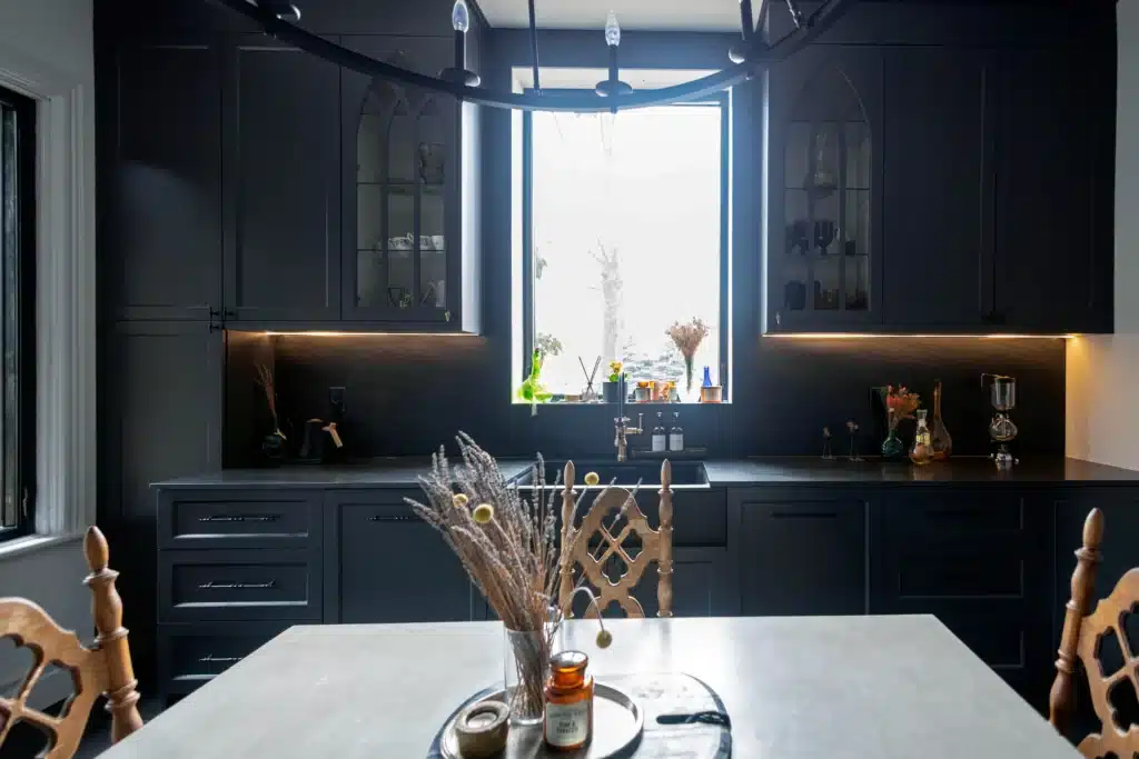 Victorian kitchen renovation in Toronto with dark custom cabinetry, farmhouse sink, and brass fixtures
