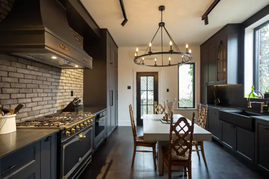 Victorian kitchen renovation in Toronto with dark custom cabinetry, farmhouse sink, and brass fixtures