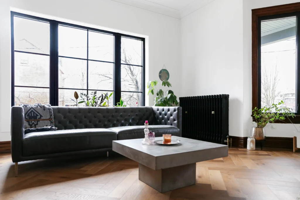Victorian living room renovation in Toronto with large window, herringbone wood flooring, and restored original details