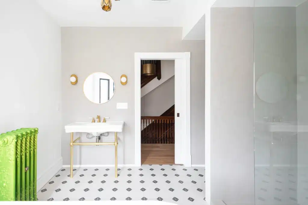 Modern bathroom renovation in Toronto Victorian home with glass shower, patterned tile floor, and vanity and mirror