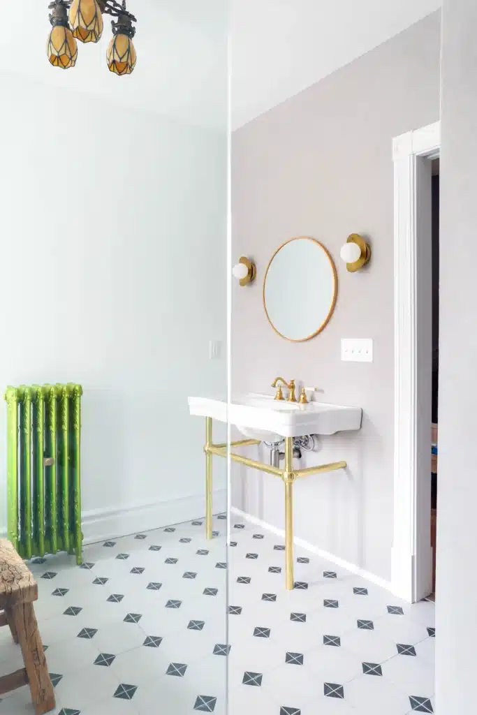 Modern bathroom renovation in Toronto Victorian home with glass shower, patterned tile floor, vanity and mirror with a green radiator