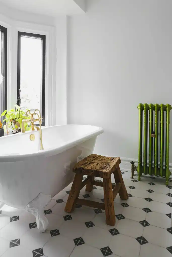 Modern bathroom renovation in Toronto Victorian home with glass shower, patterned tile floor, modern soakin tub with a green radiator