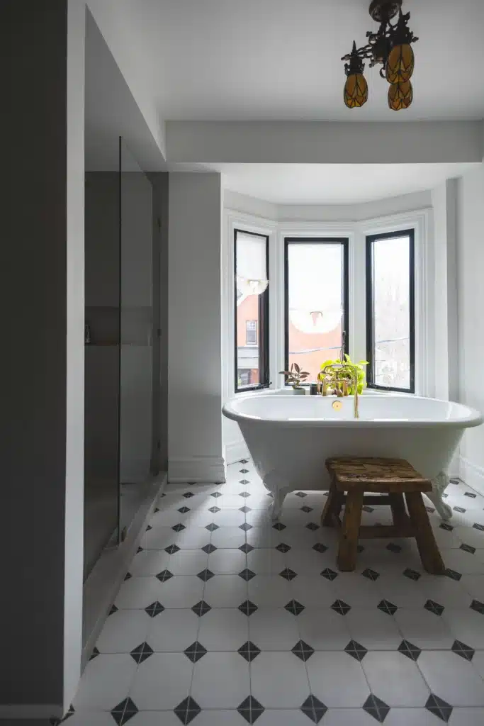 Modern bathroom renovation in Toronto Victorian home with glass shower, patterned tile floor, modern soakin tub with a green radiator