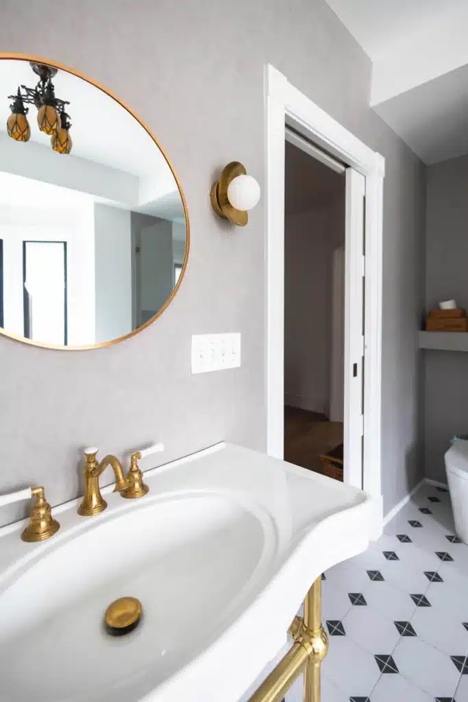 Close up image of a Modern bathroom renovation in Toronto Victorian home with glass shower, patterned tile floor, modern soakin tub with a green radiator